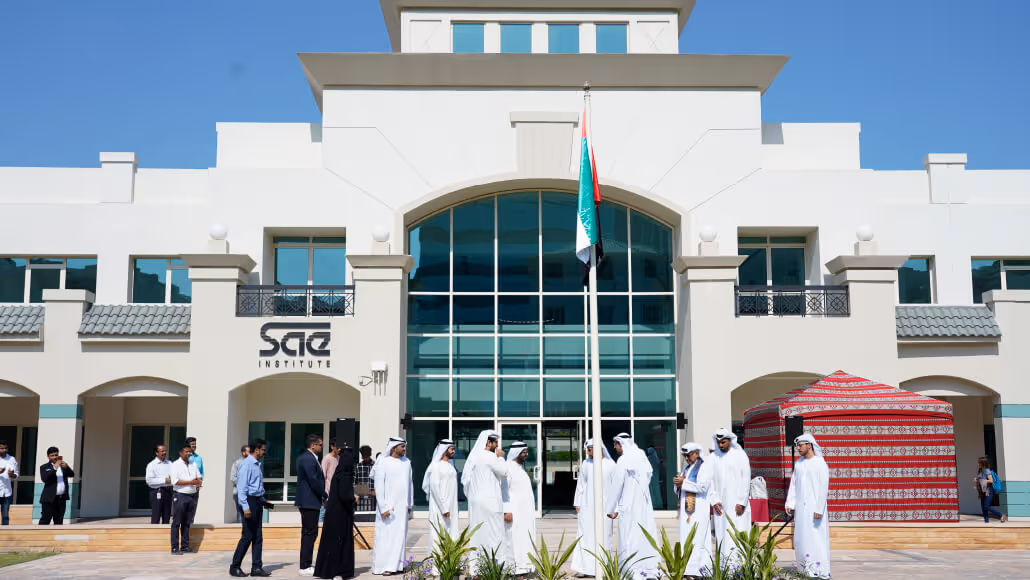 Group in Emirati attire outside SAE Institute at Dubai Knowledge Park.