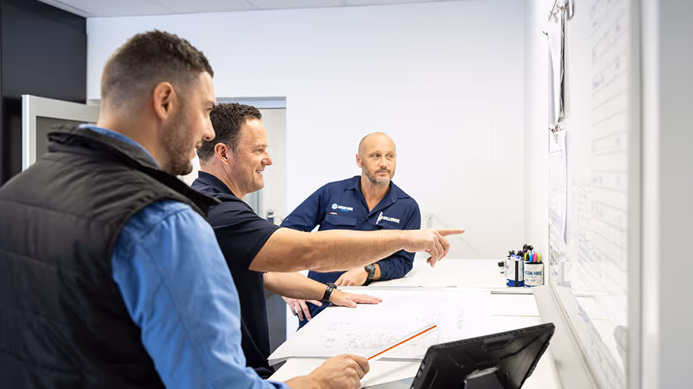 Two Aircon Hire staff discussing paperwork at a desk
