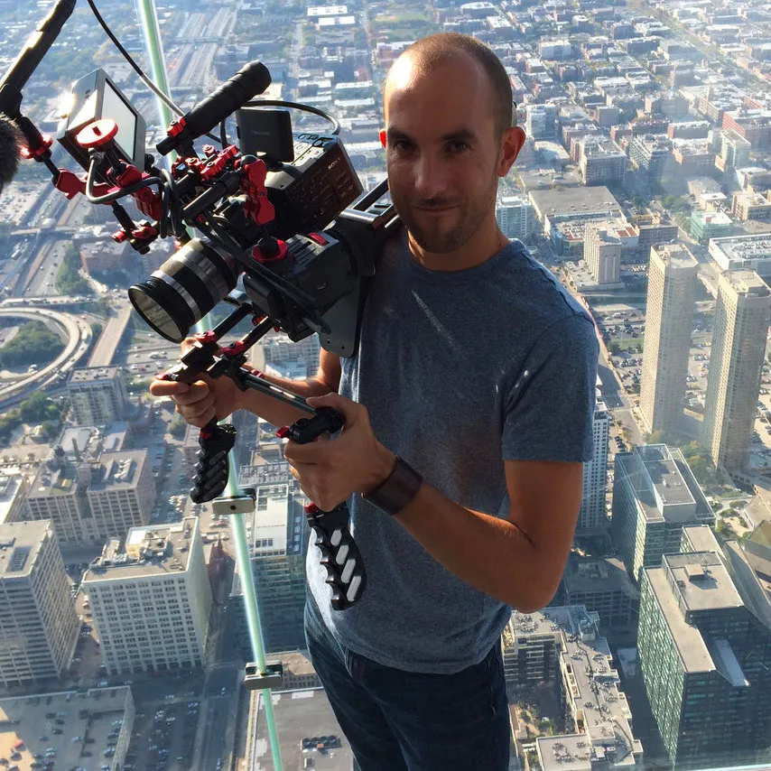adam standing above a city holding a camera