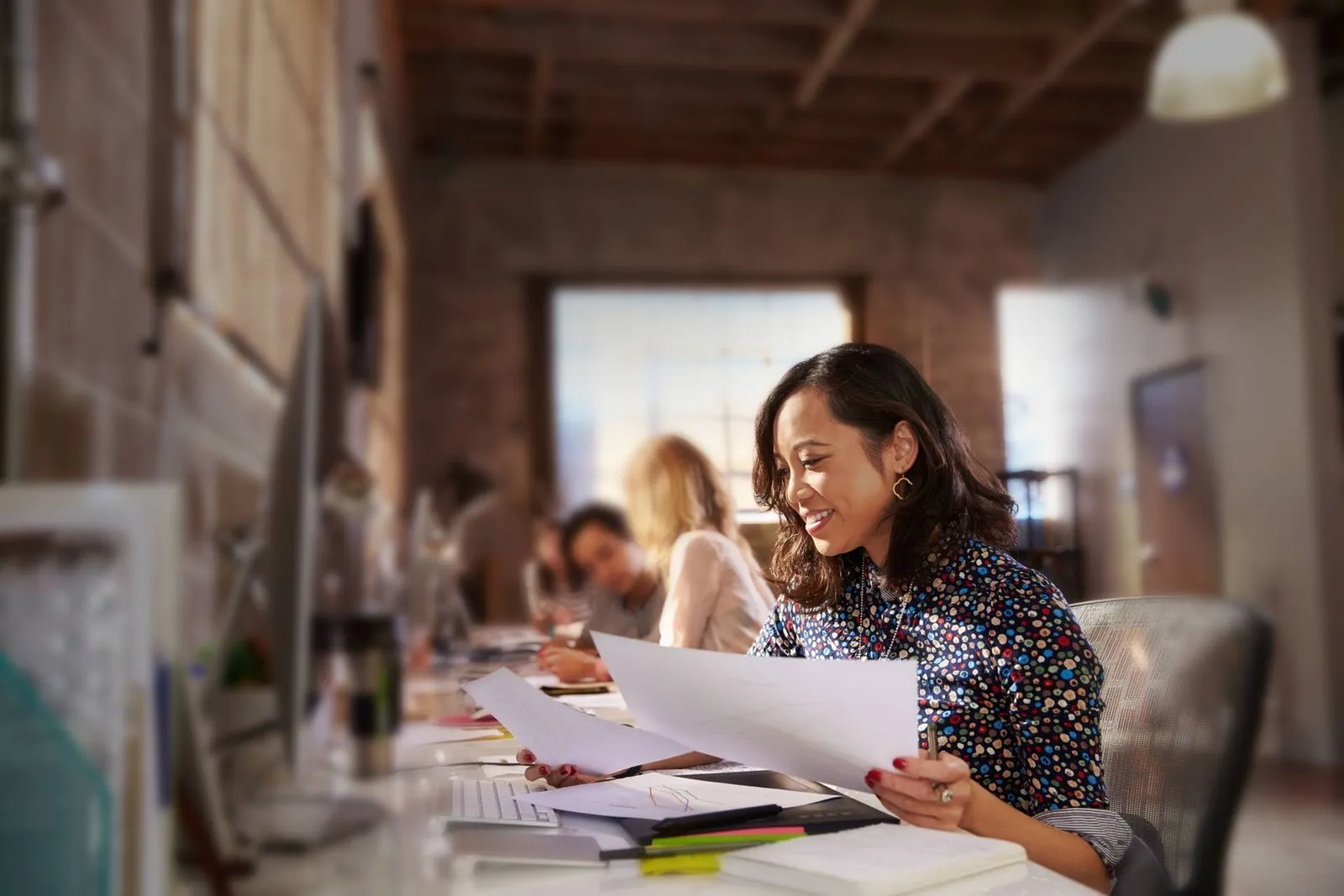 A person holding up papers and brainstorming for a marketing project in the Maven office, capturing a creative and collaborative work session.
