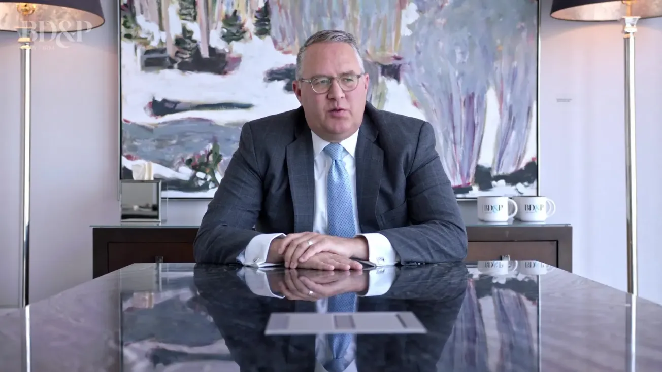 A man being interviewed at a boardroom table, showcasing the agency's expertise in creating professional video content for the legal industry.