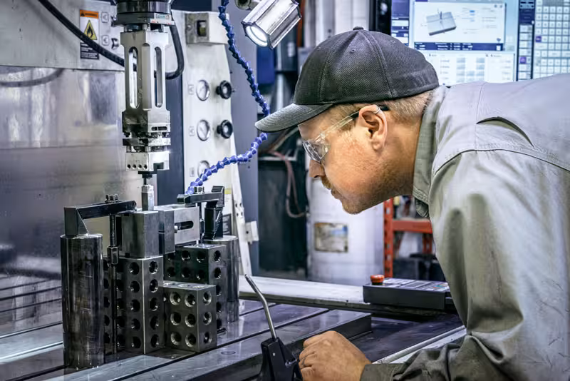 A worker operating a CNC machine while wearing safety glasses, captured for a Fidelity Manufacturing project.