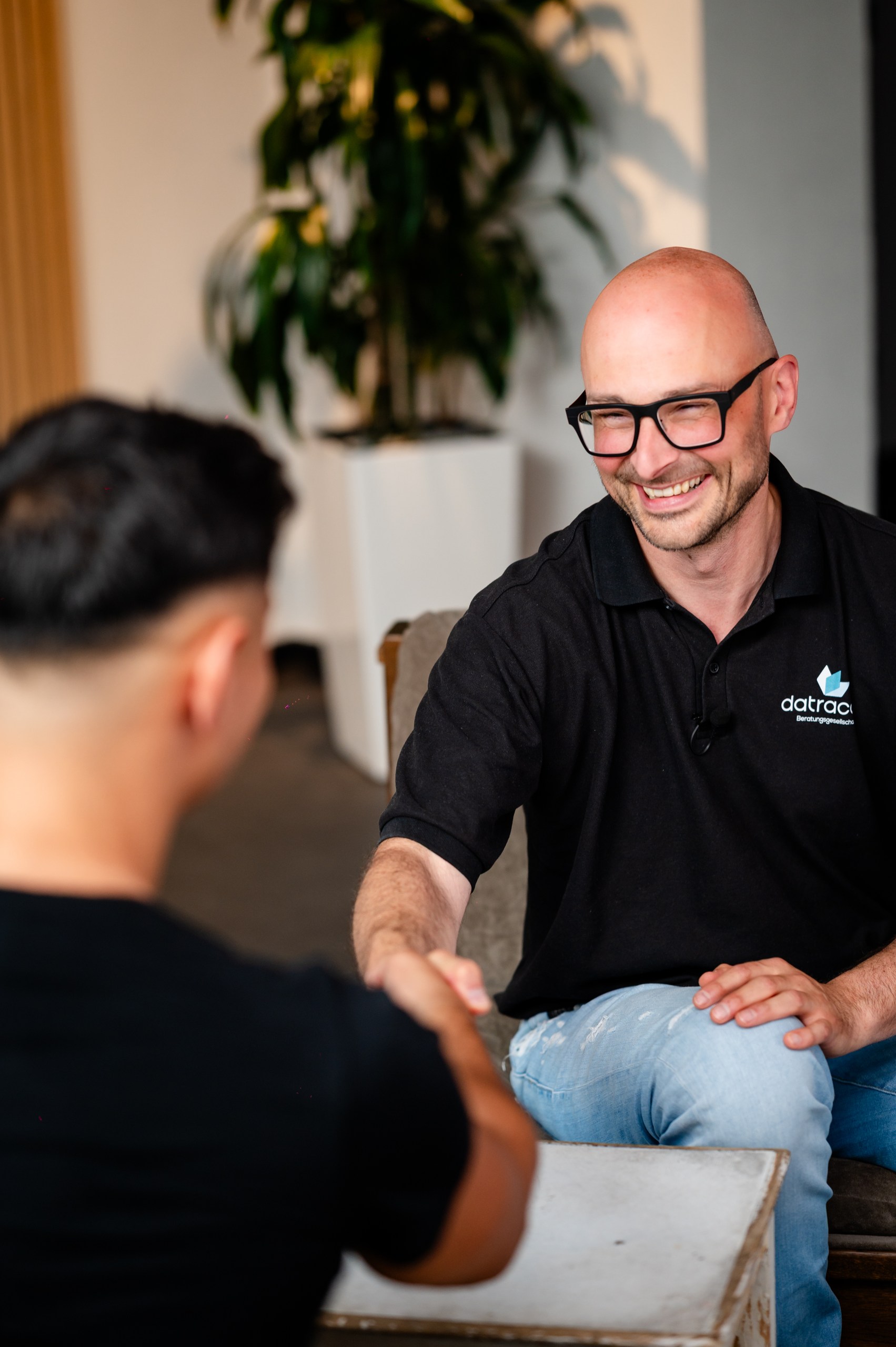 DG Business Fotografie: Lächelnder Geschäftsmann beim Händeschütteln im Büro