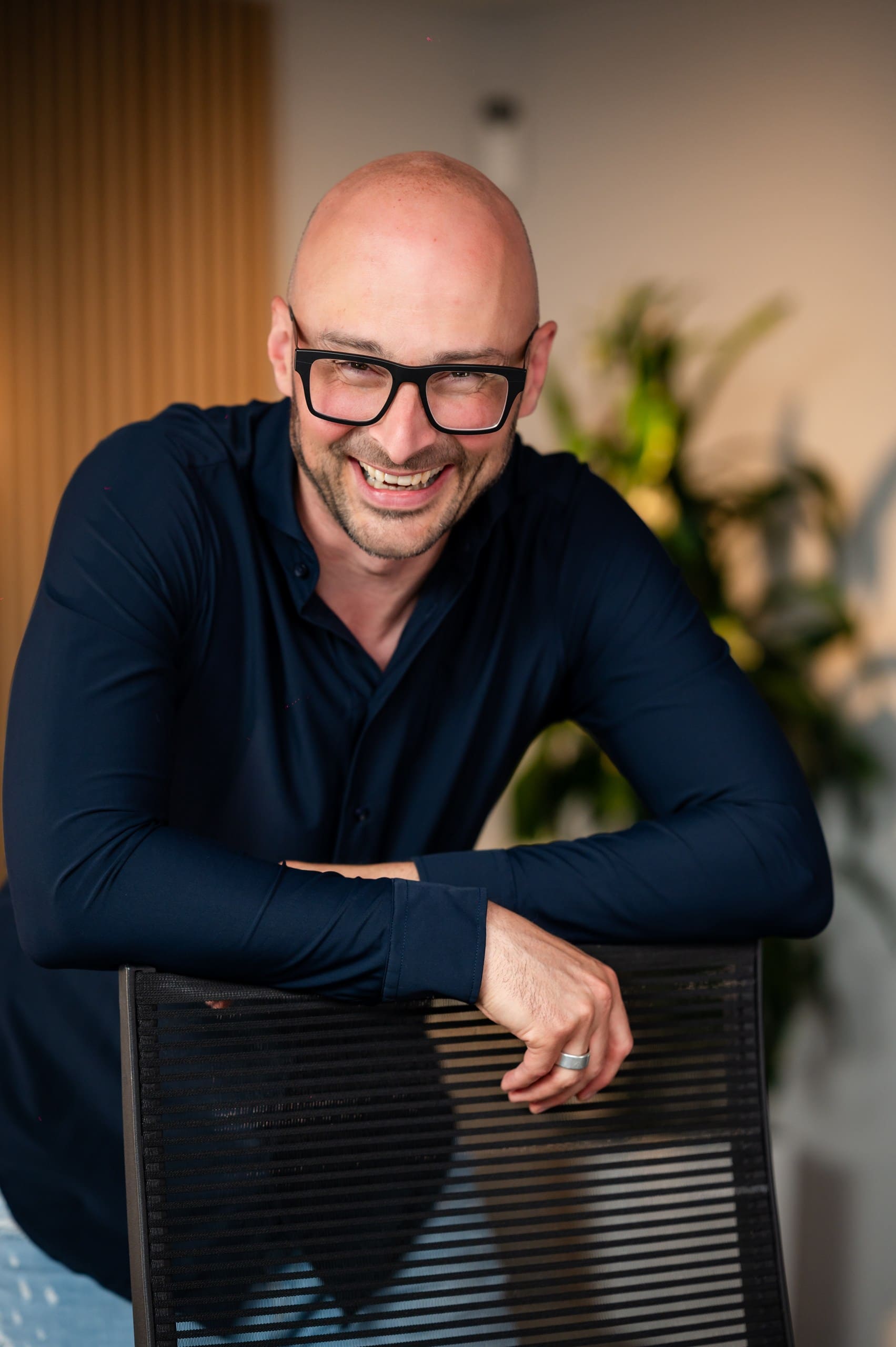 Professionelle Geschäftsfotografie eines lächelnden Mannes im dunklen Hemd