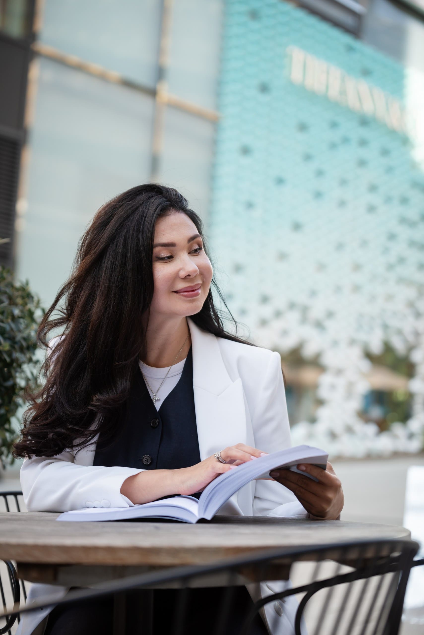 Geschäftsfotografie einer Frau, die ein Buch im modernen Büroumfeld liest