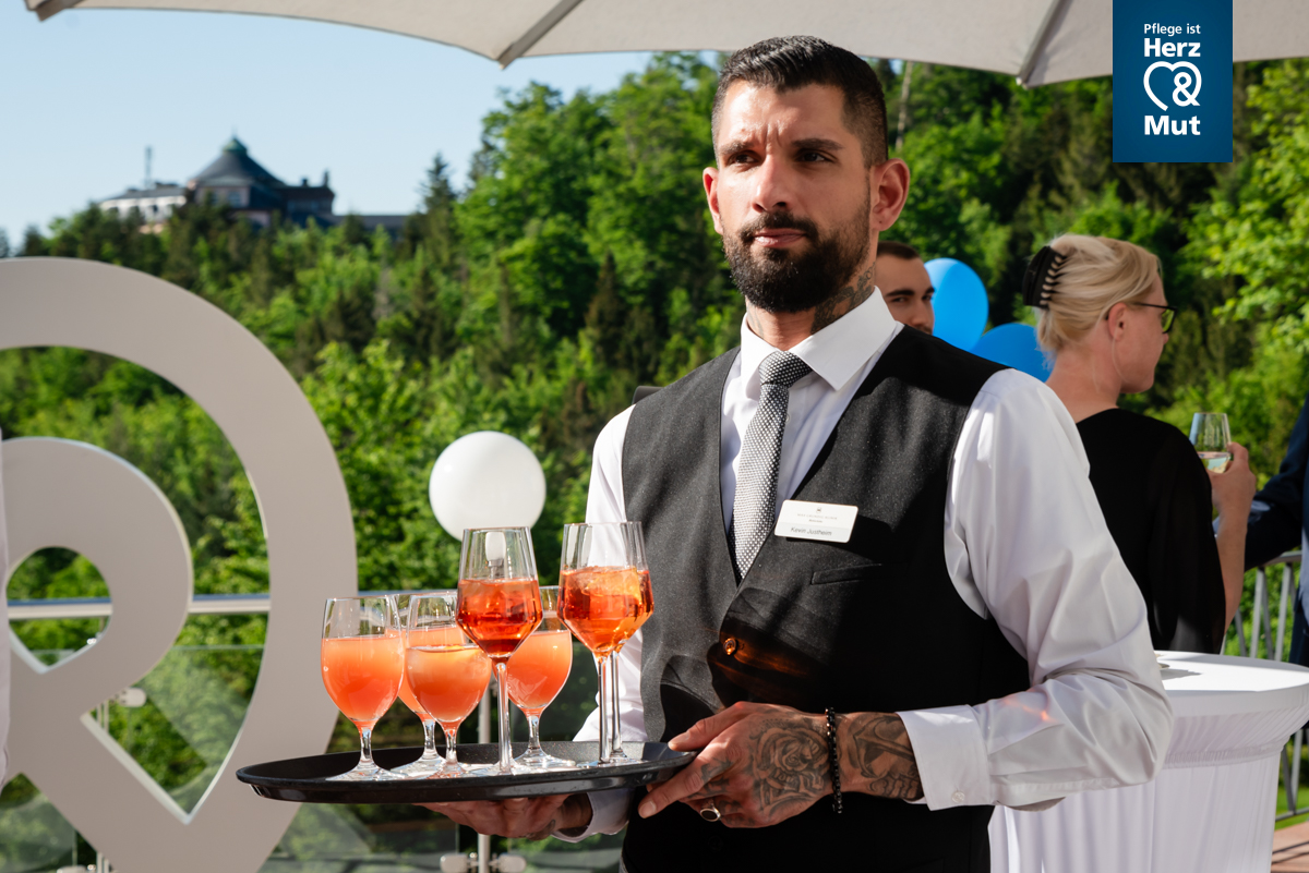 Professionelle Business-Fotografie eines Kellners mit Cocktails auf Terrasse