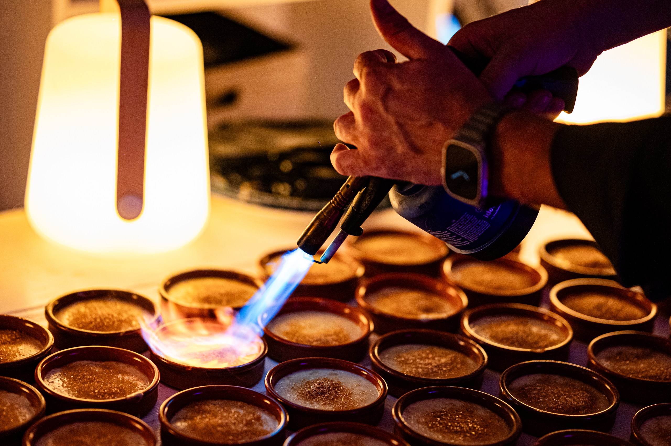 Professionelle Fotografie der Crème Brûlée-Zubereitung in der Gastronomie-Küche