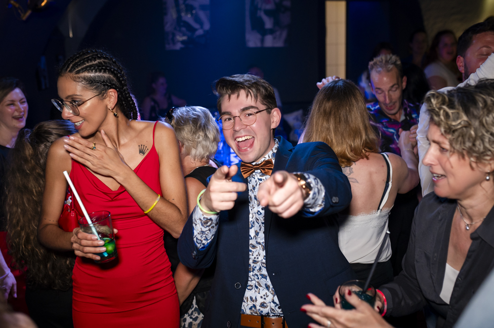 Professionelle Fotografien von ausgelassener Party mit lachenden Gästen in festlicher Kleidung