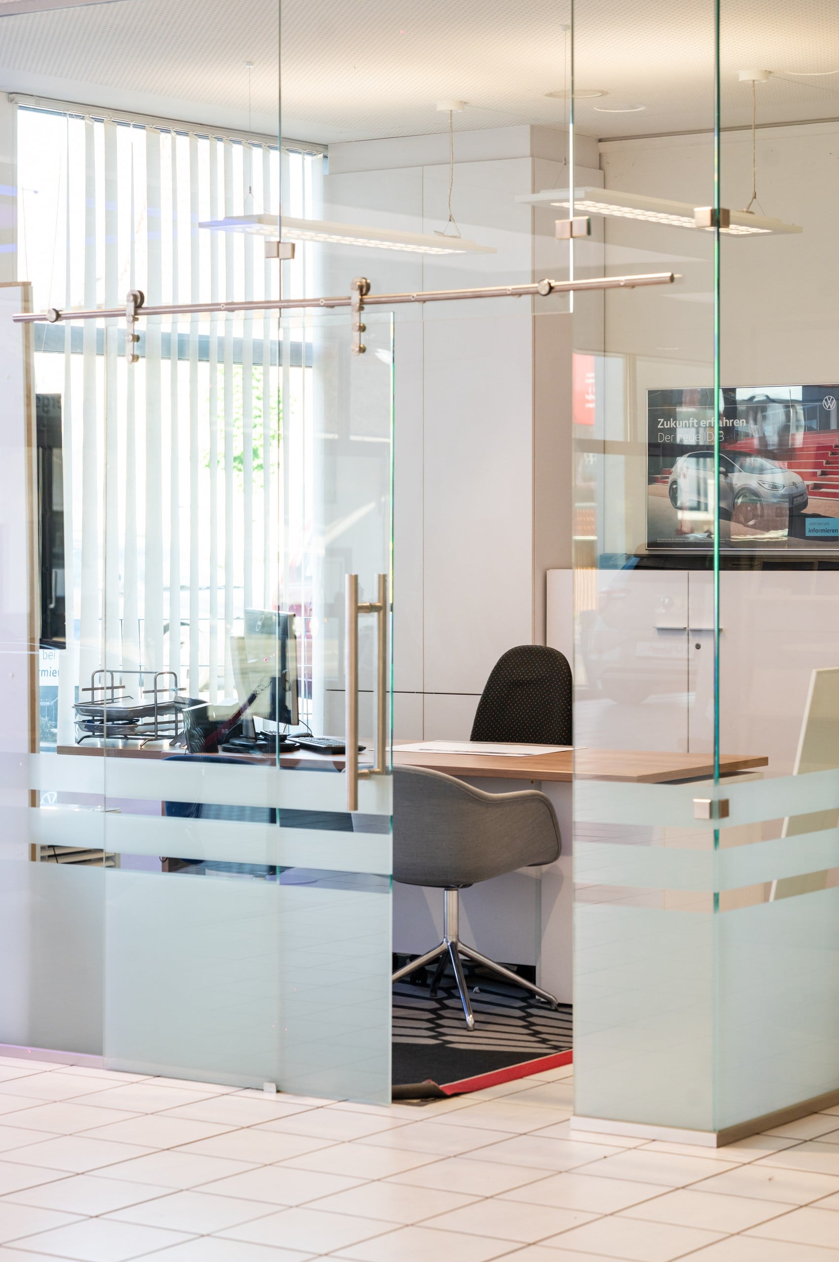 Professionelle Geschäftsfotografie eines modernen Glasbüros mit Arbeitsplatz