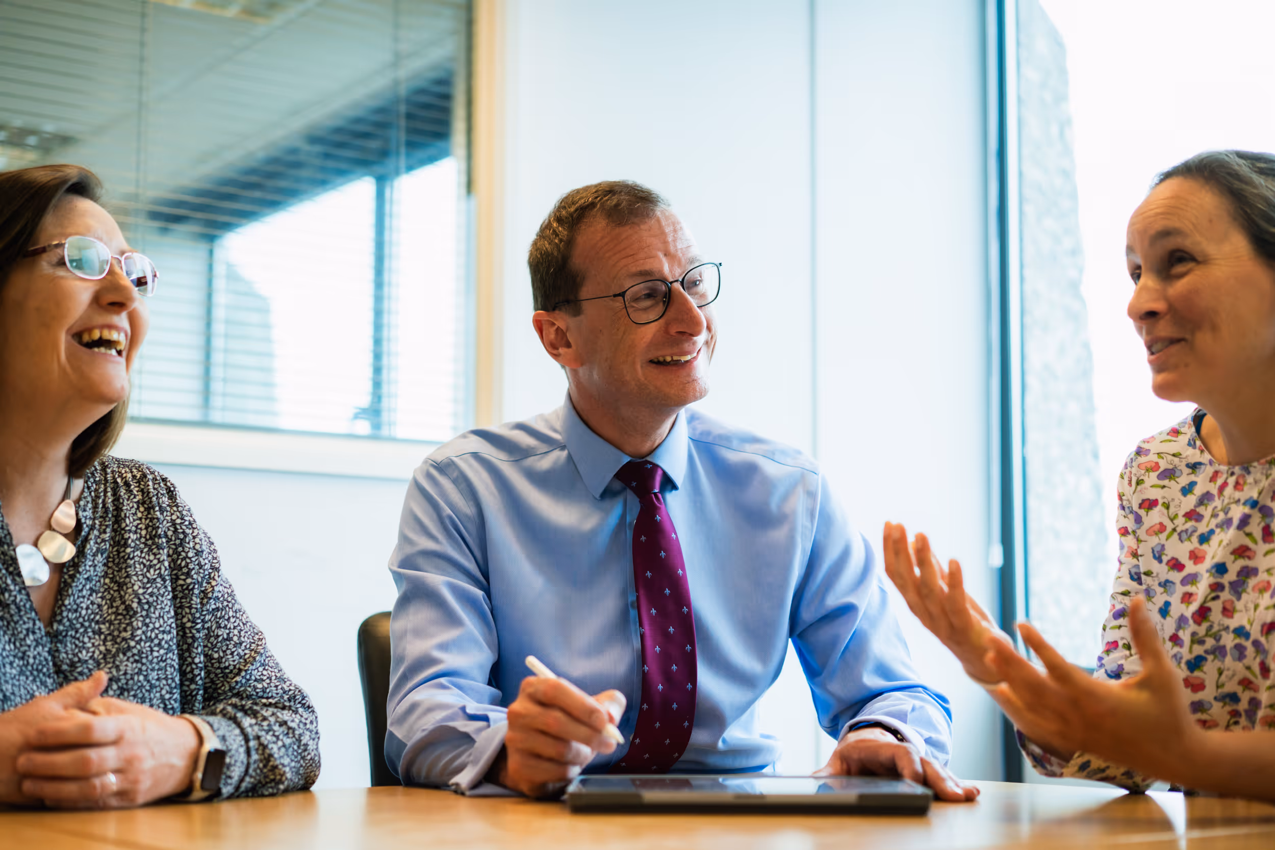 David Culley sat at a table with two women, engaging in conversation and smiling. 