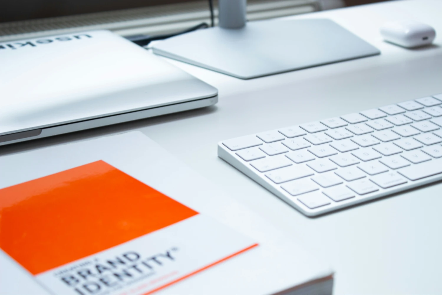 Keyboard, branding book, monitor and laptop
