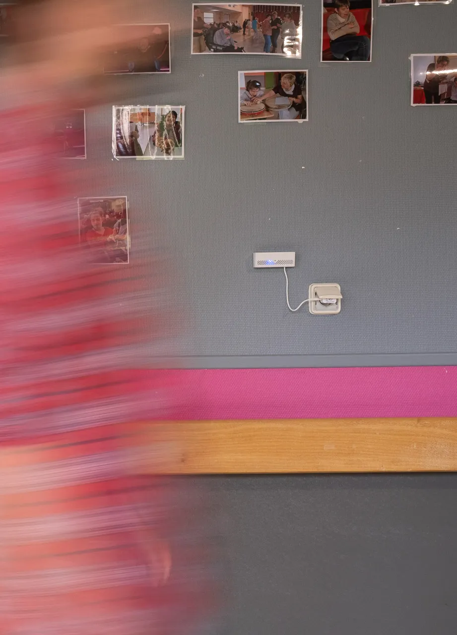 Photo of the orikio box plugged into a hallway at MAS, with someone walking past.