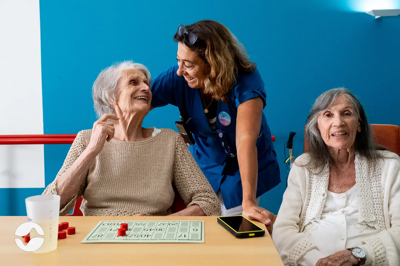 Caregiver during a moment of life with a resident, Orikio smartphone on the table.