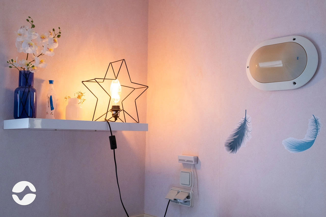 Boîtier Orikio branché au mur dans une chambre de résident.