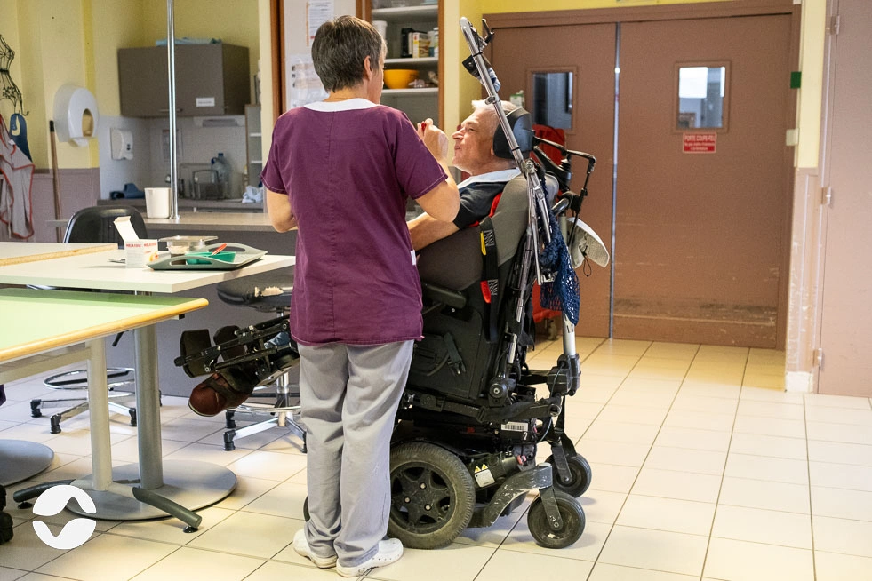 AES avec un résident en salle commune lors du dîner.