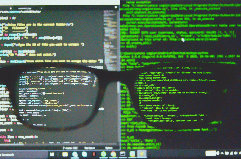 A computer screen with glasses in front, symbolizing meticulous quality assurance (QA) testing and detailed software inspection.