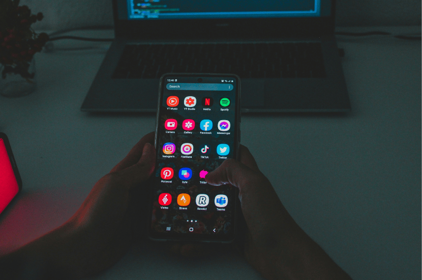 A smartphone screen displayed in front of a laptop, symbolizing cross-platform mobile app development and responsive design workflows.