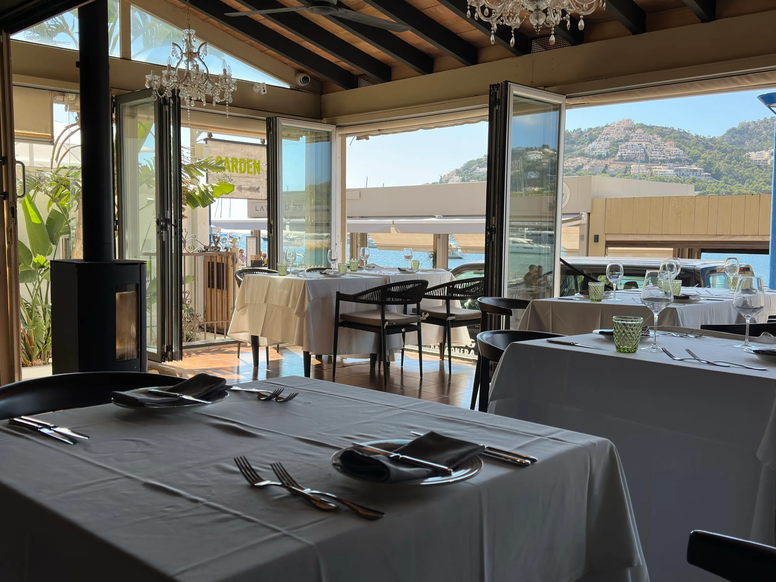 Elegant restaurant interior with mountain view, white tablecloths, and crystal chandeliers