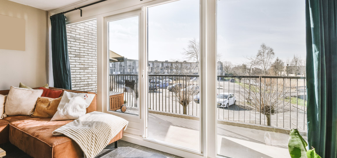  Sliding glass patio doors opening a Birmingham home extension onto the garden with slim modern frames.