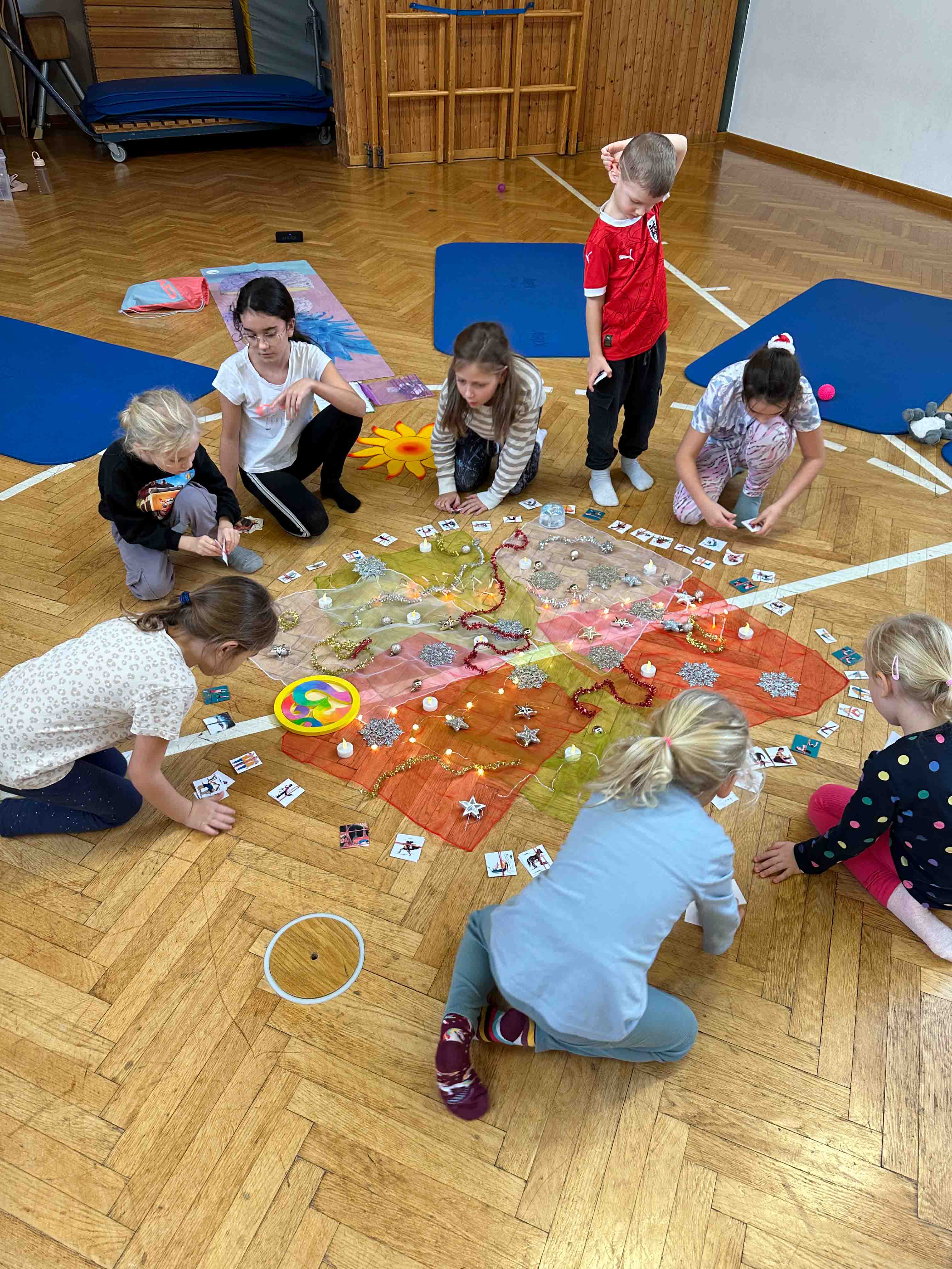 Kinder sitzen im Kreis und gestalten kreativ.