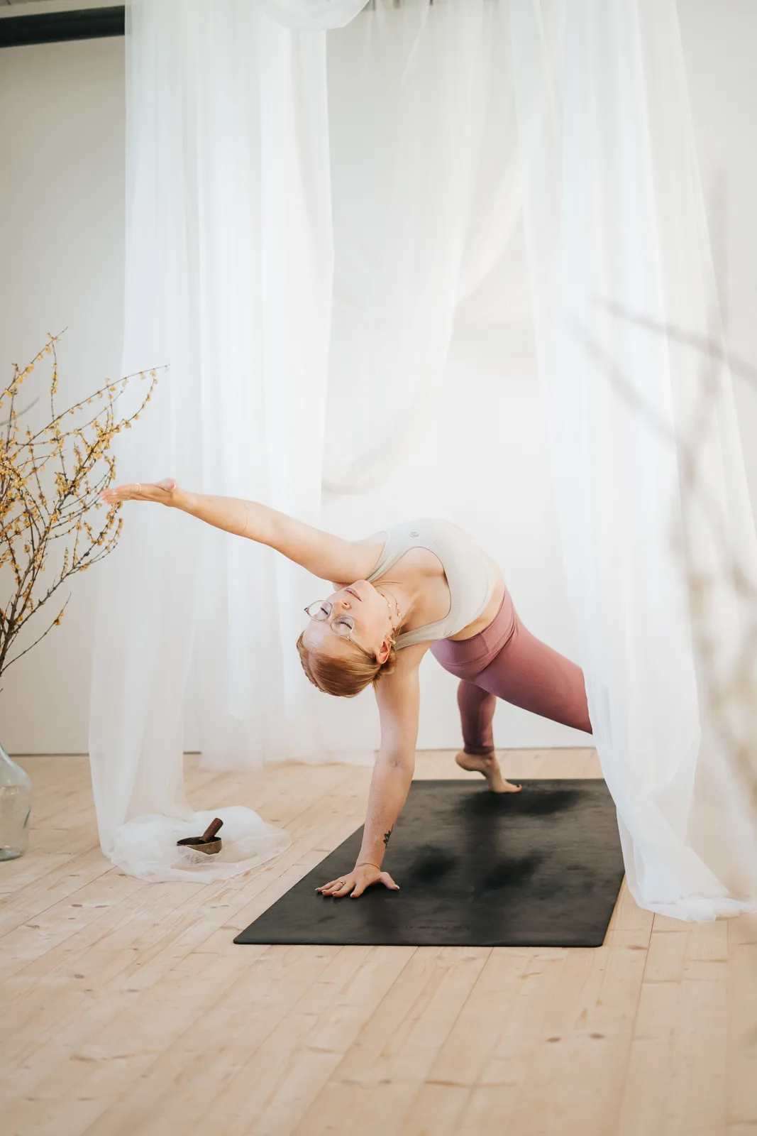 Yogalehrerin führt eine dynamische seitliche Stützhaltung im Vinyasa Power Flow aus, aufgenommen in einem Yoga-Studio in Melk, Niederösterreich.