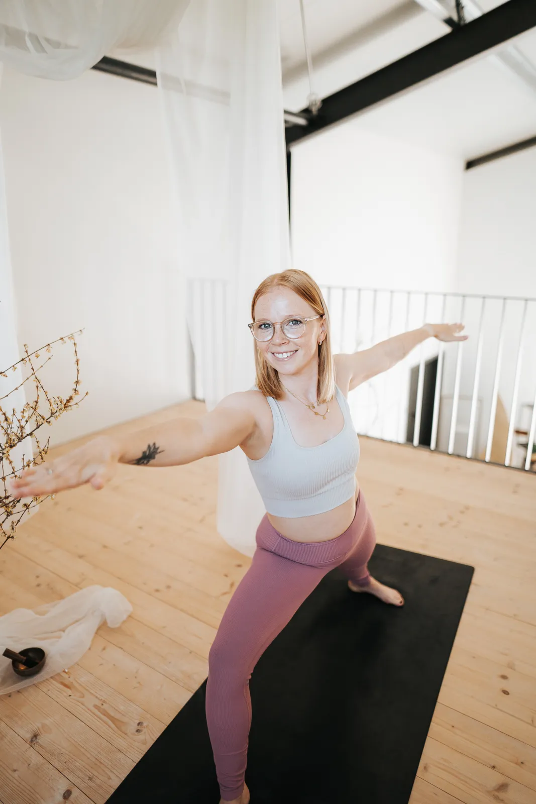 Yoga Lehrerin im Krieger II während einer Vinyasa Power Flow Einheit in St. Pölten.