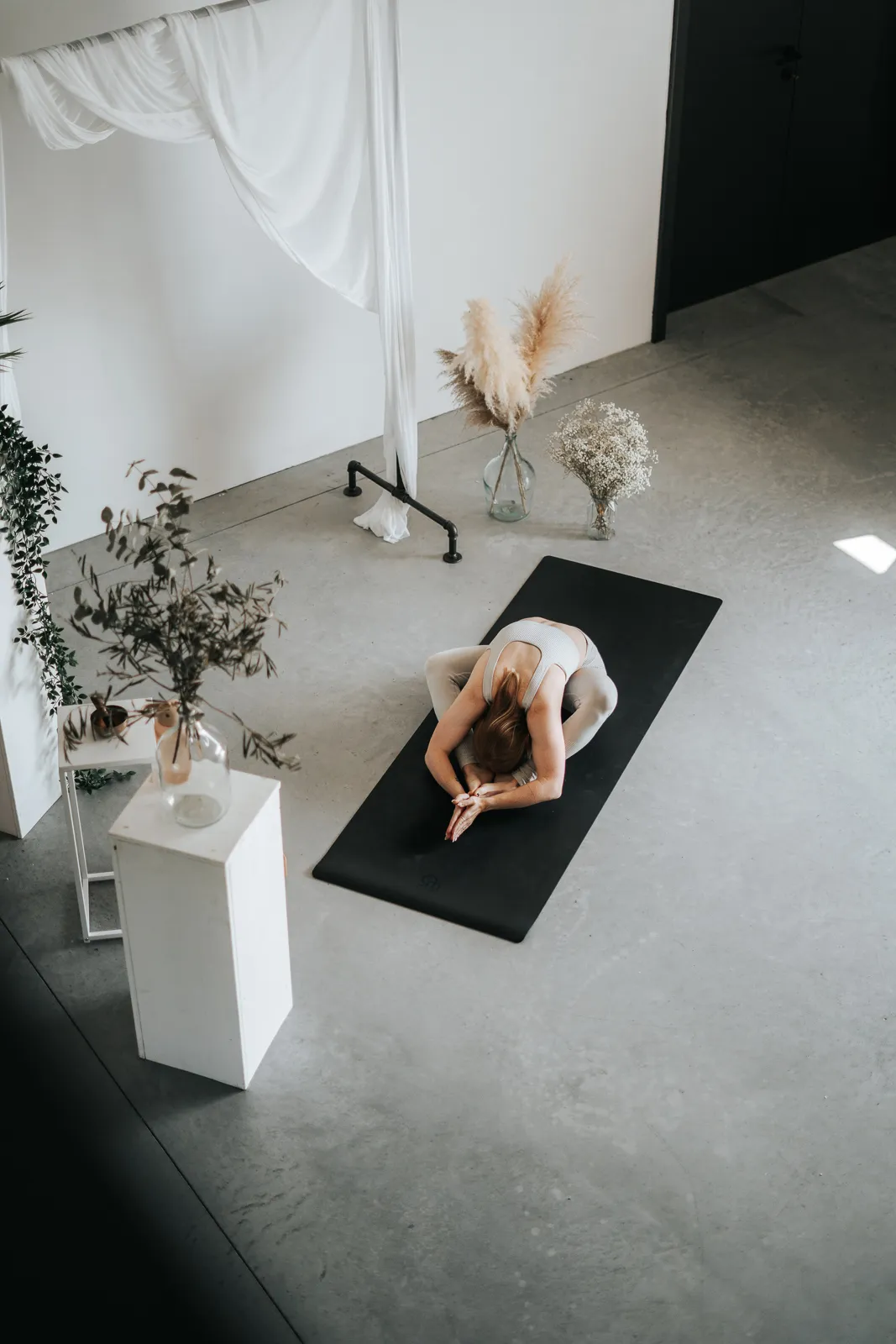 Frau in einer tiefen Yoga Dehnung auf der Matte – Achtsamkeit und Entspannung im Hatha Yoga.