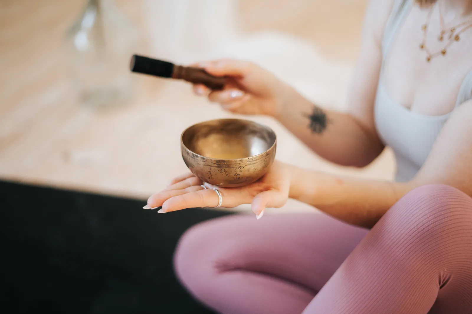 Yoga Lehrerin hält Klangschale in den Händen – Meditation und Klang für Entspannung in St. Pölten.