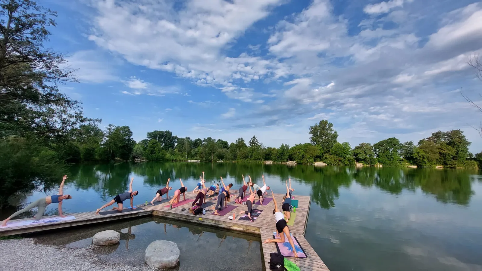 Teilnehmerinnen üben seitliche Dehnungen beim Yoga am Ebersdorfersee in Niederösterreich.