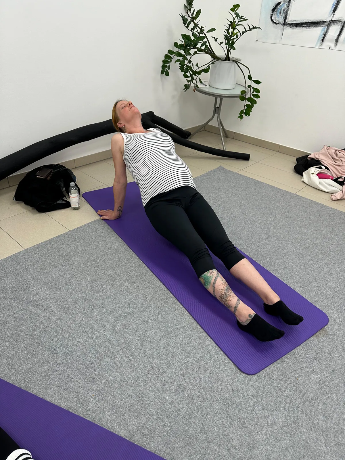 Schwangere Frau in einer nach hinten geöffneten Position auf der Yogamatte, Fokus auf Entspannung und Atemübungen im Schwangerschaftsyoga.
