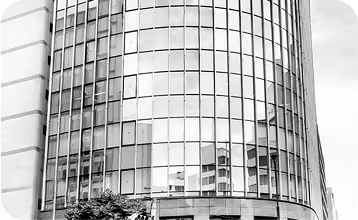 Modern glass and steel office building with curved reflective facade