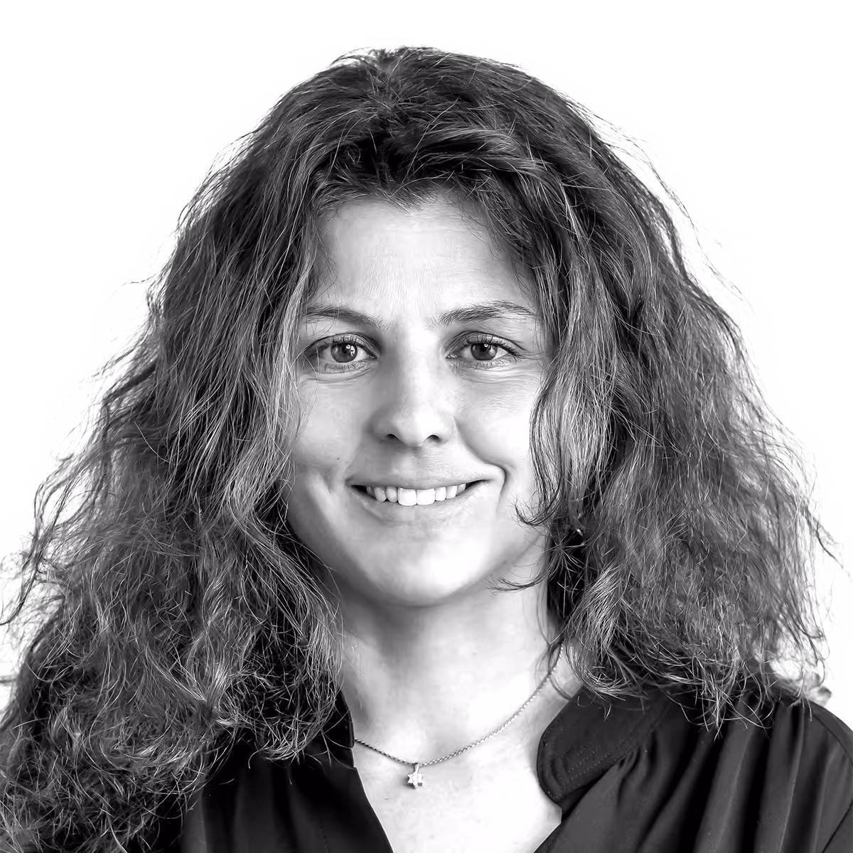 Smiling woman with curly hair in black and white portrait