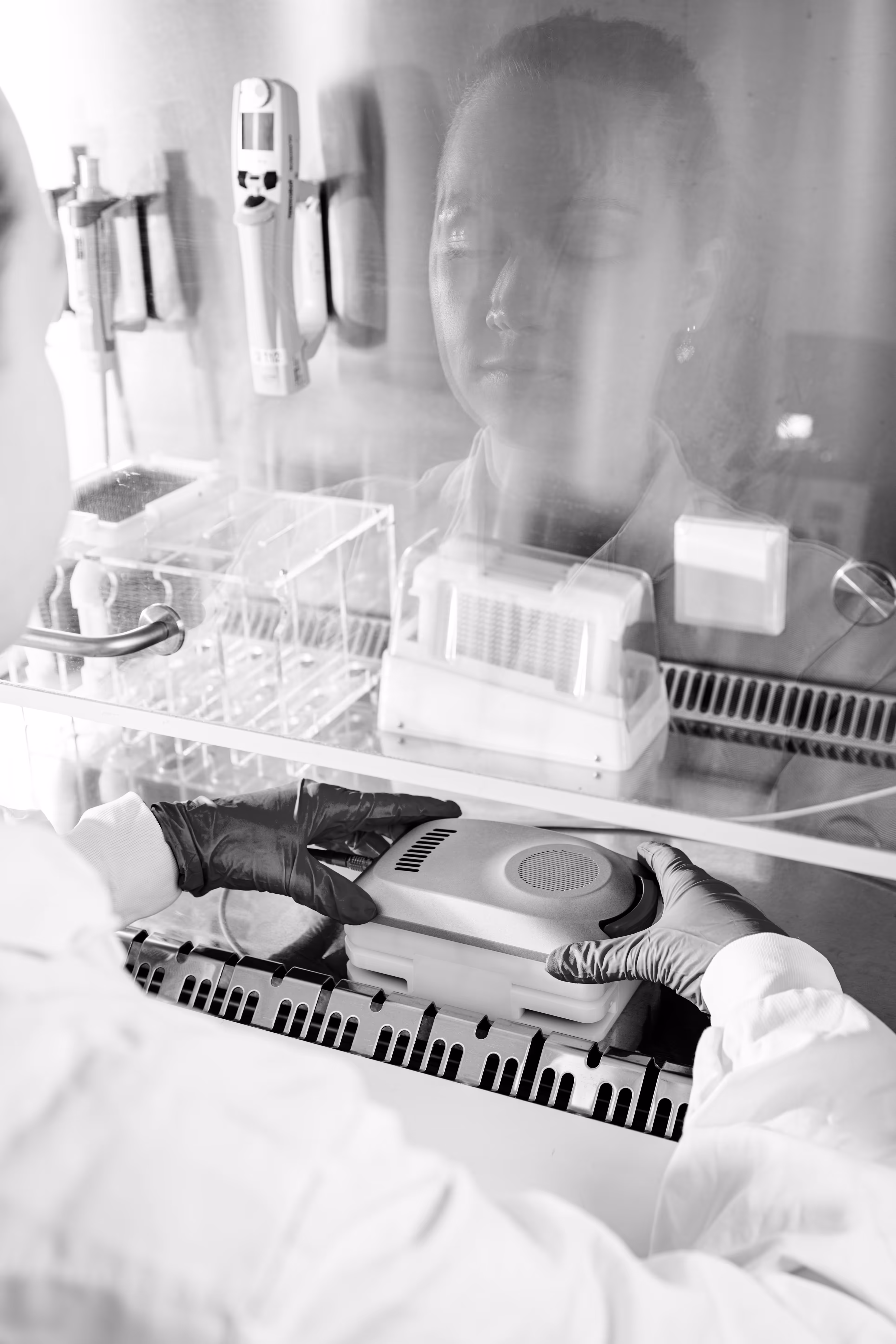 Medical professional using laboratory equipment with gloved hands