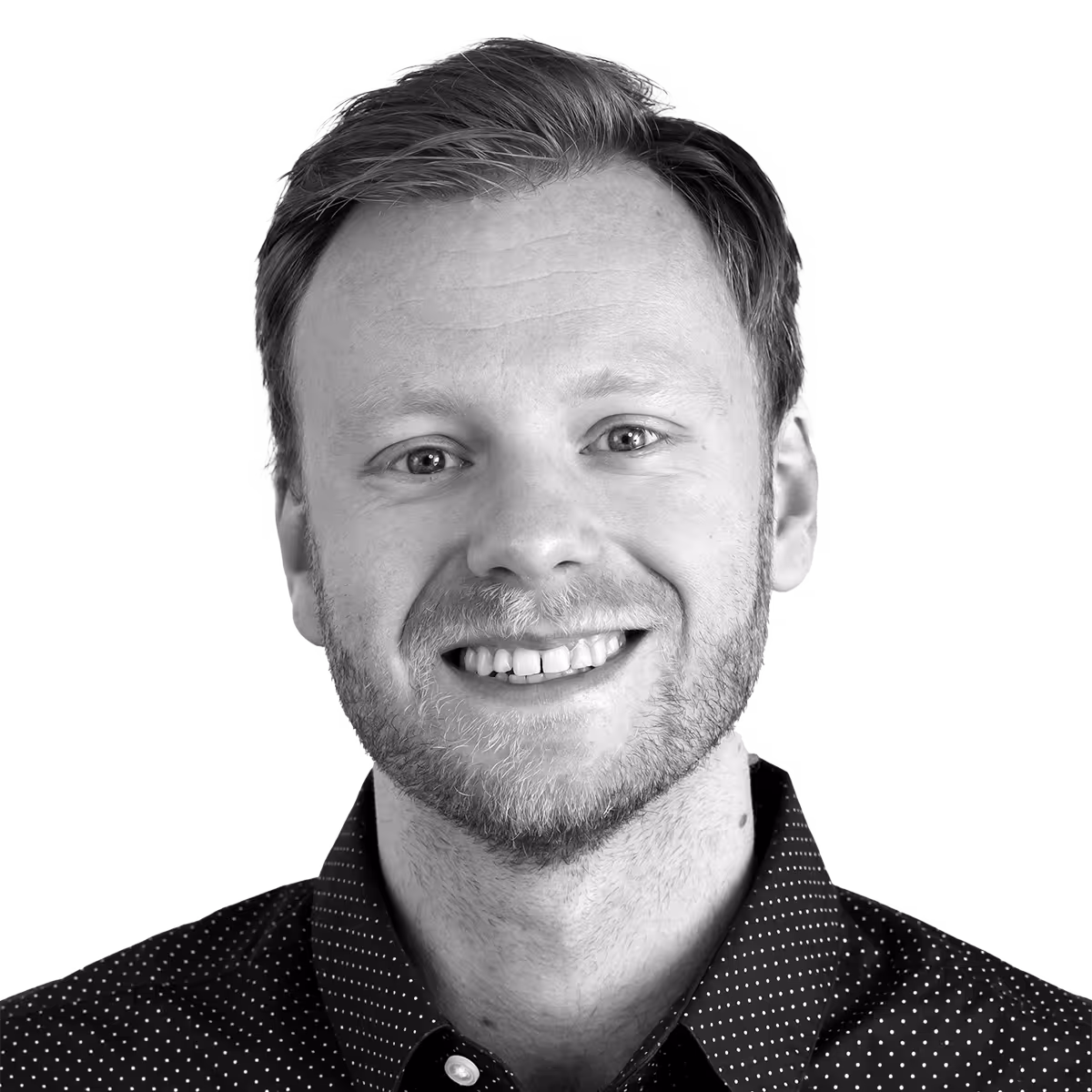 Smiling person in black and white with polka dot shirt