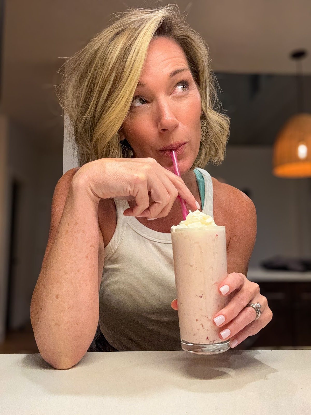 Midlife woman enjoying a homemade high-protein smoothie to support energy and strength.