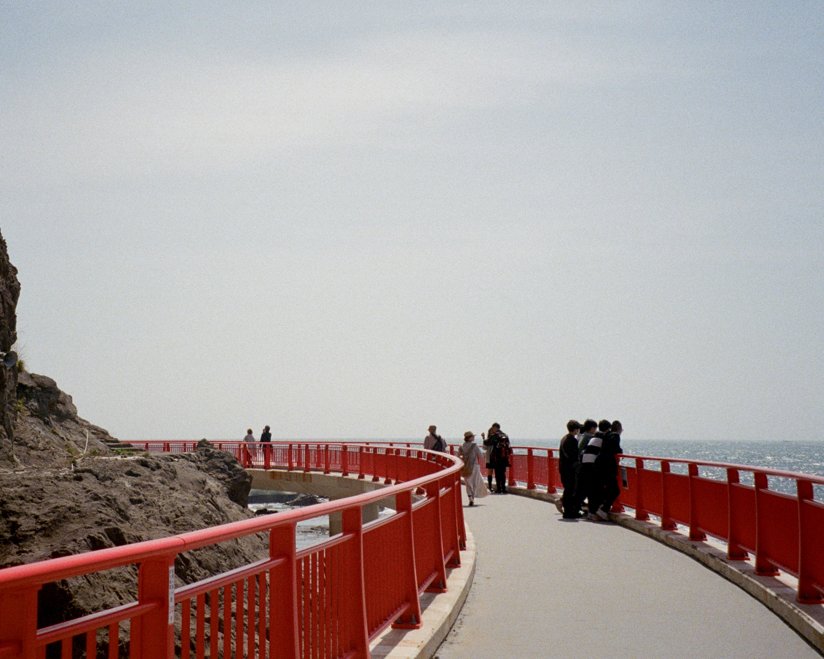 35mm photography of red bridge over the ocean