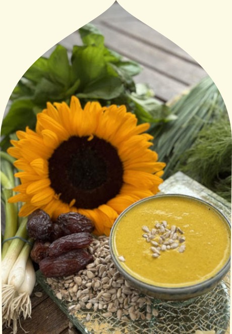 A photo of a bowl of NOTS Gourmet Salad Dressing, nestled iin sunflowers, sunflower seeds, herbs and vegetables