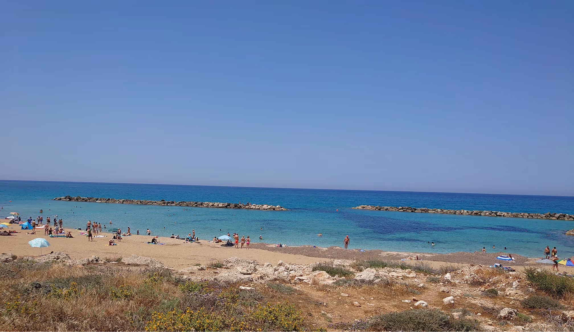 A picture of a historical place, Aphrodite`s rock, the image shows a beach filled with rocks