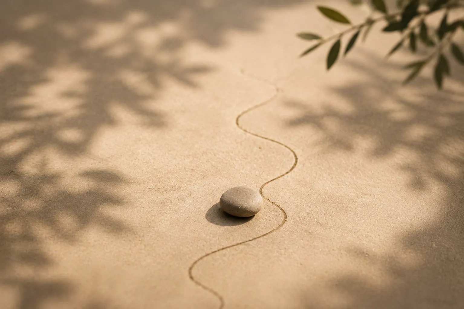 Stein auf einer geschwungenen Linie im Sand – Sinnbild für Coaching