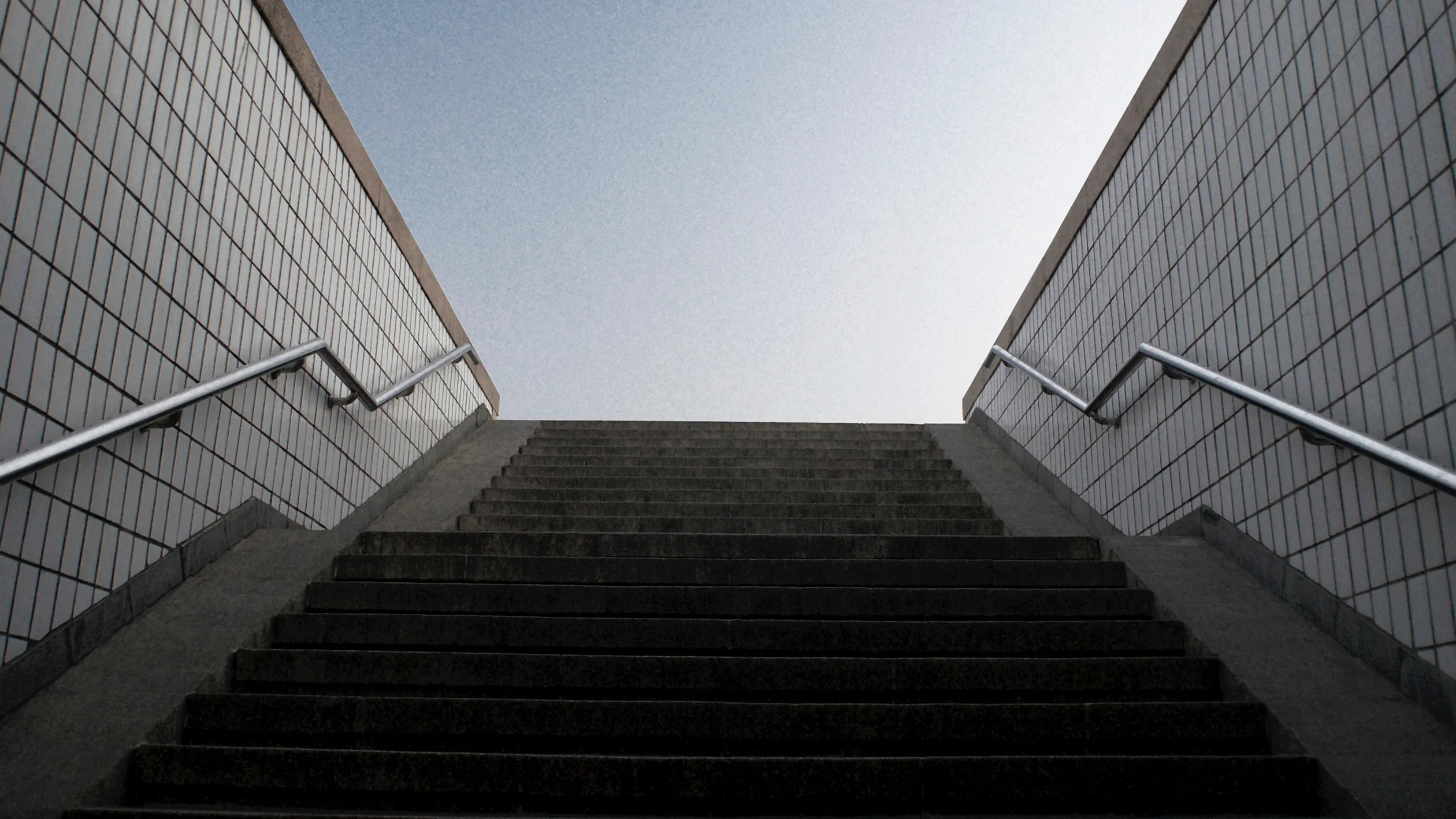 A person stands confidently on a skateboard, balancing with one foot on the board and the other on the ground.