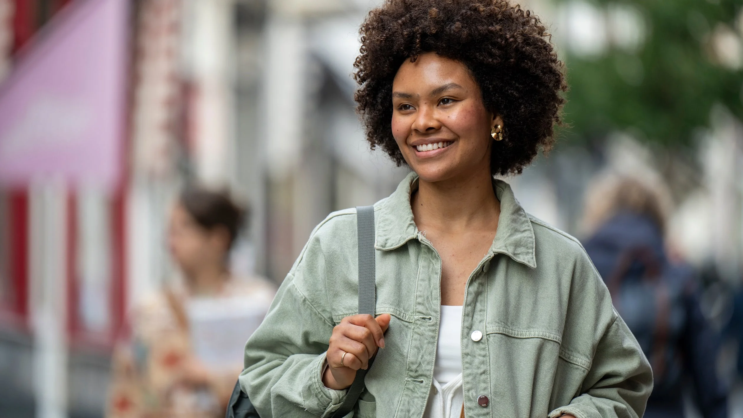 A smiling woman with an afro hairstyle, radiating joy and confidence.