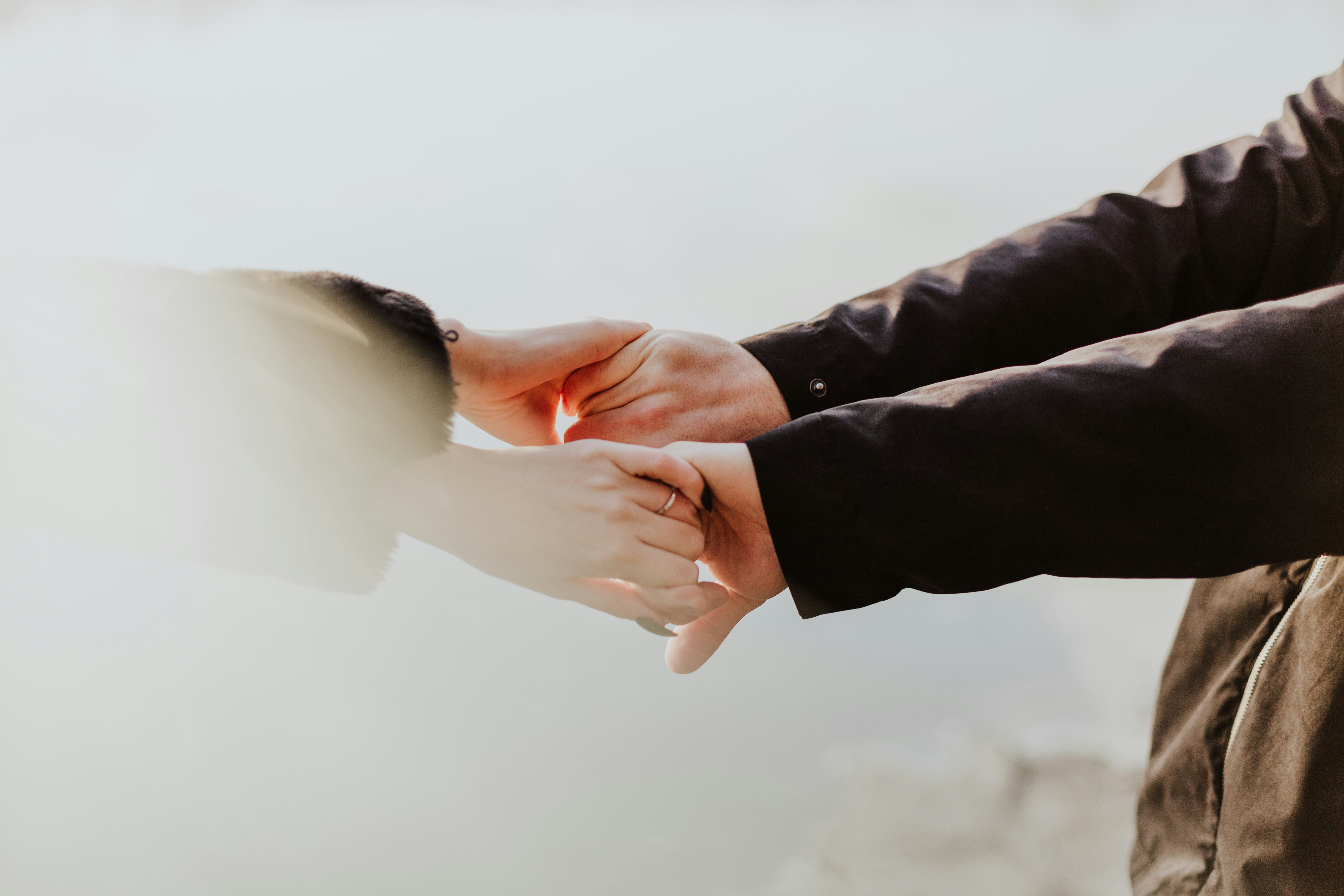 A patient and clinician holding hands during a supportive cancer detection consultation