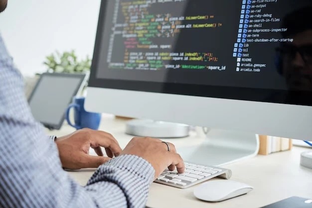 Programador desenvolve código em um computador, exibindo programação em uma tela de desktop. A imagem destaca o trabalho em tecnologia e desenvolvimento de software.