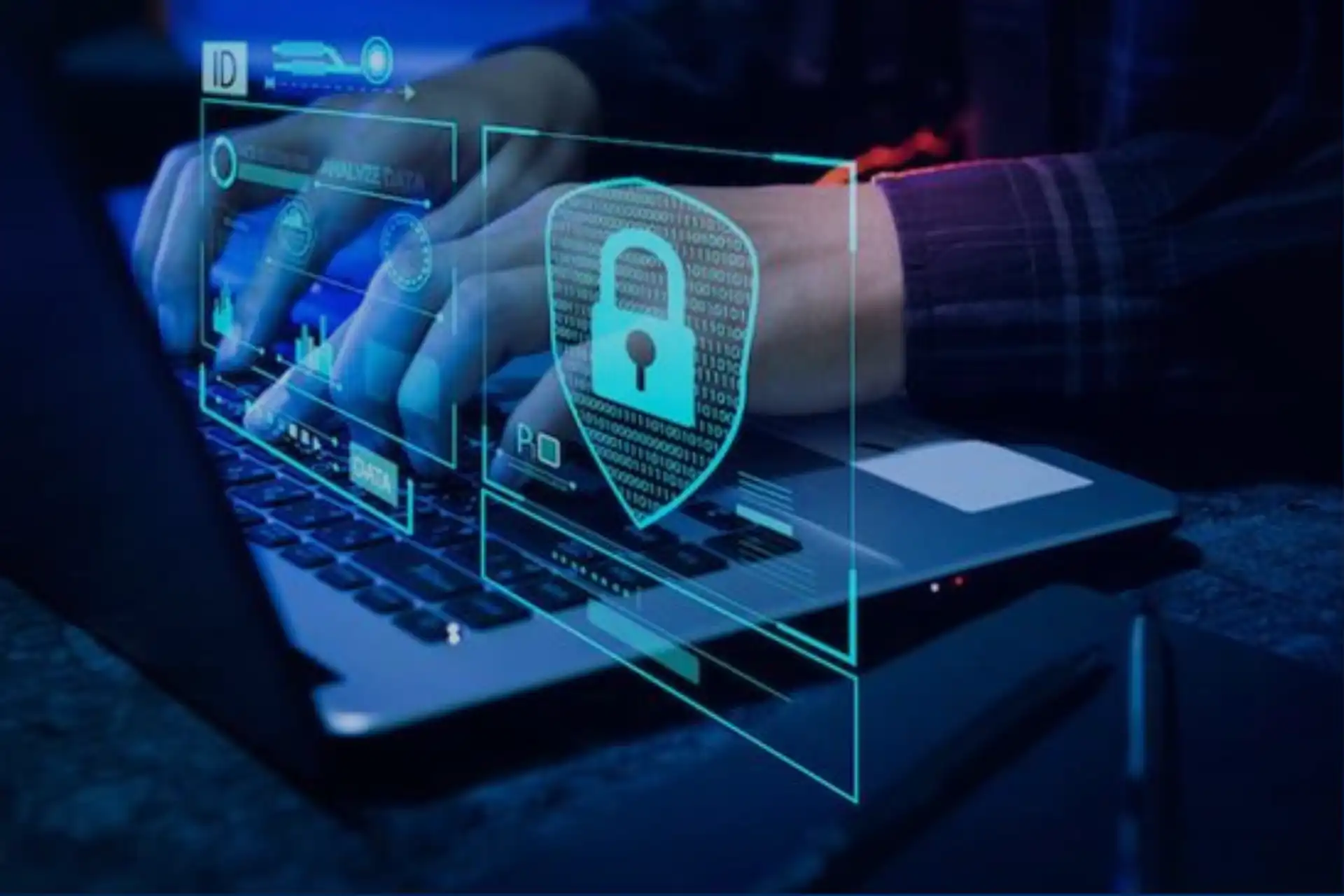 Pessoa digitando em um laptop exibindo elementos de segurança digital, como um cadeado, representando proteção de dados e privacidade online.