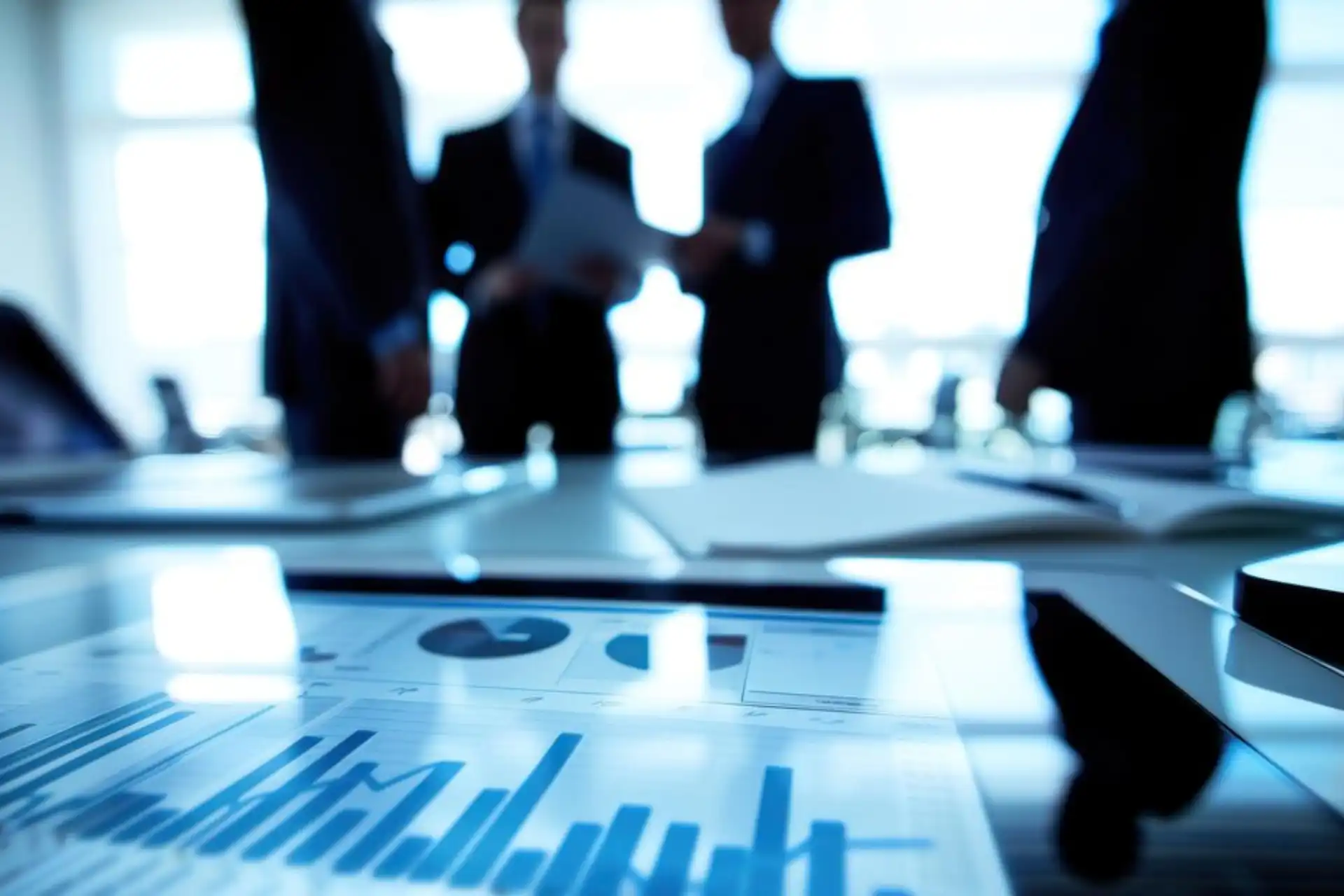 Reunião de negócios com gráficos e relatórios em destaque, representando dados financeiros e análise de desempenho.