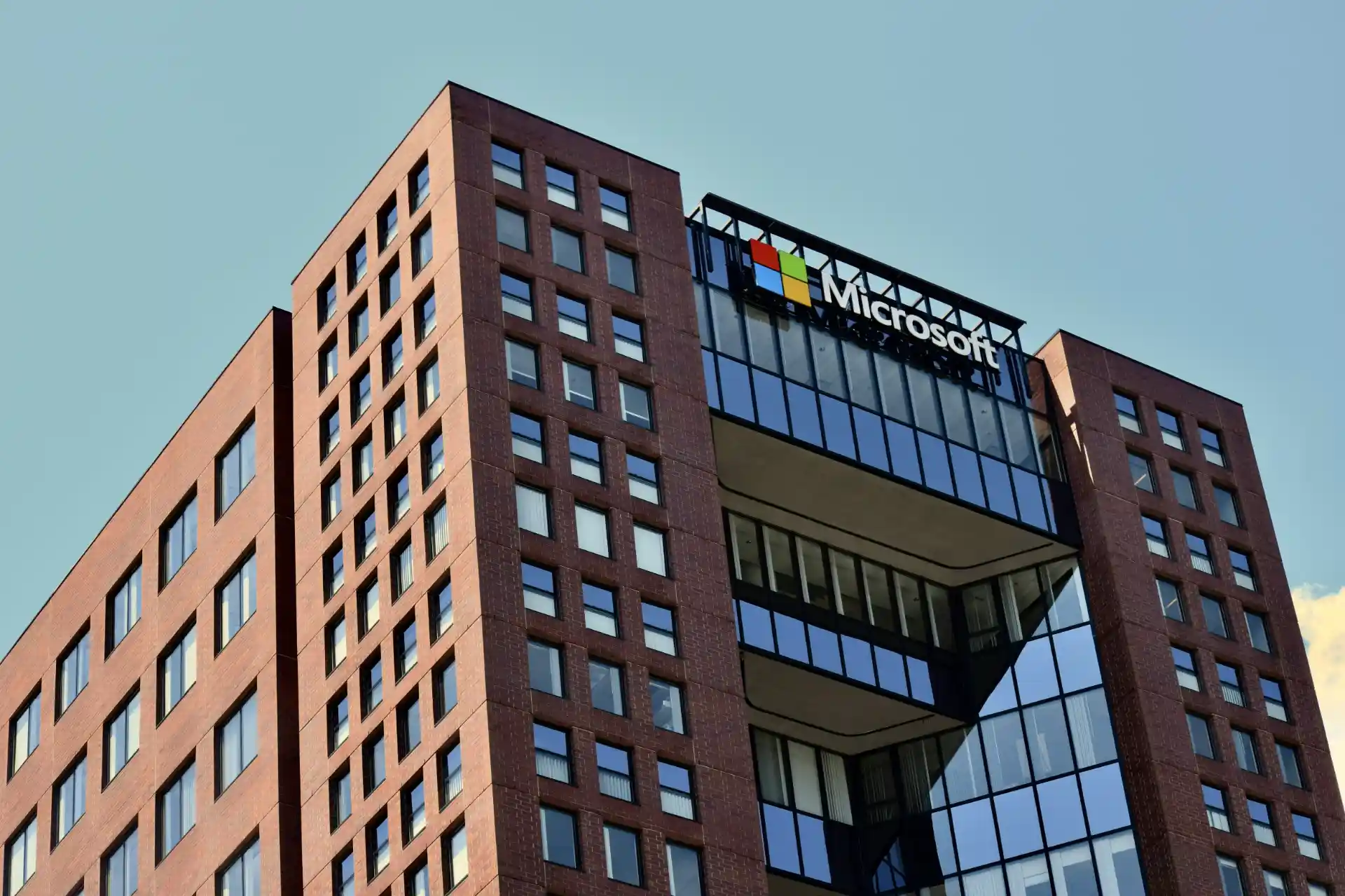 Prédio da Microsoft com foco na segurança digital, ilustrando tema de SharePoint sob ataque, críticas na governança de acessos e cibersegurança.
