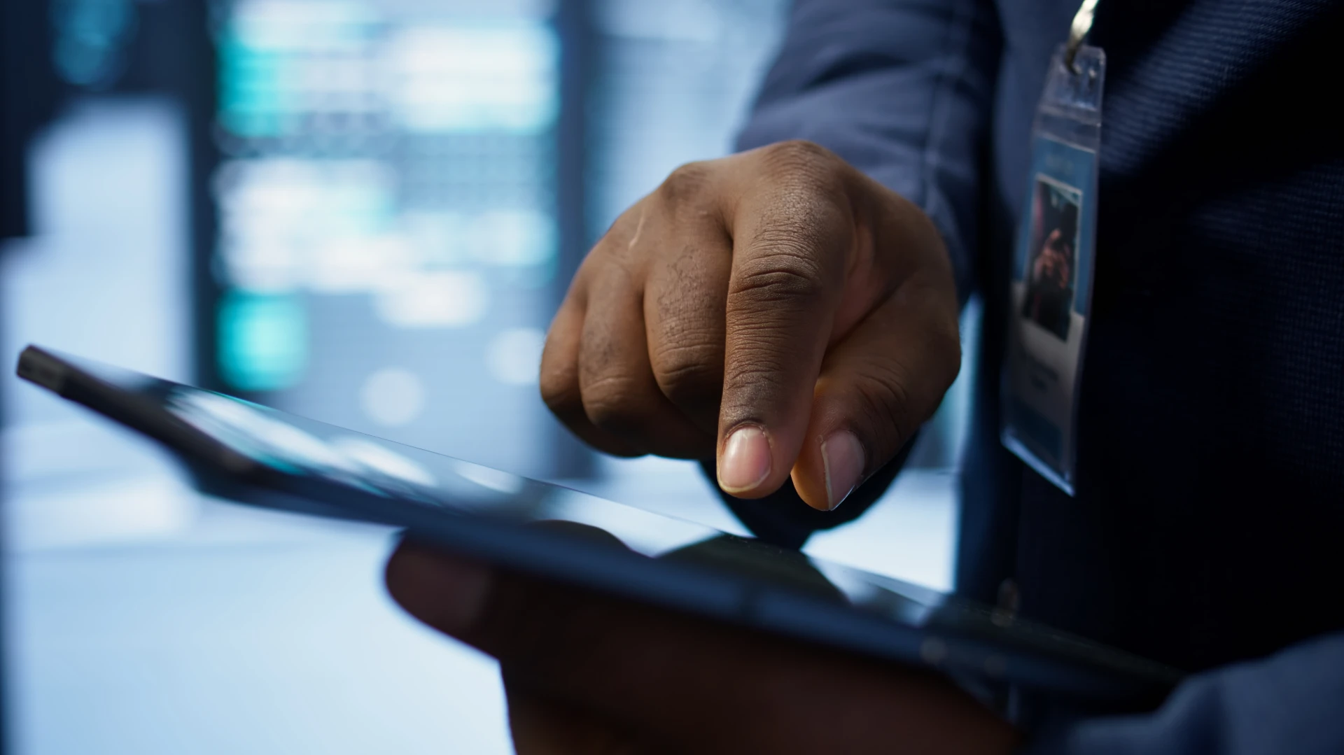 Homem de terno usando um smartphone em ambiente corporativo, evidenciando tecnologia e negócios.