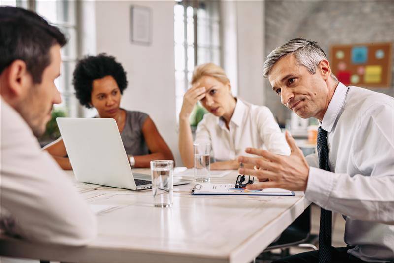 Reunião de equipe discutindo erros comuns de governança e falhas em compliance, destacando a importância do compliance contínuo na gestão empresarial.