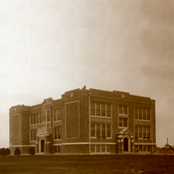 A pixelated photo of a two story building that is the first high-school in San Juan, Texas. The architecture is reminiscent of the Palazzo style of buildings found in larger schoolhouses of this time.