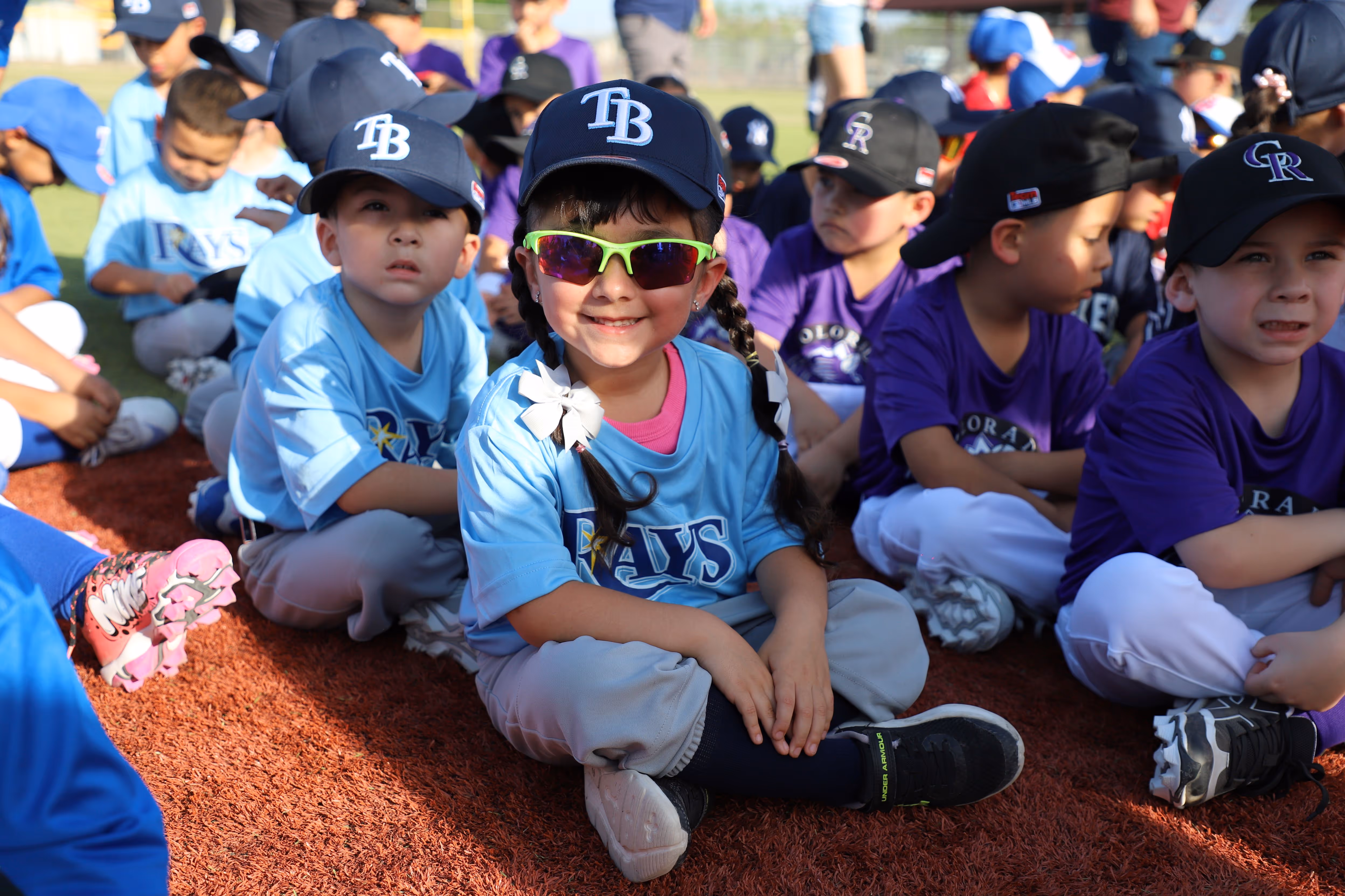 Cute children sitting patiently during a sports event.